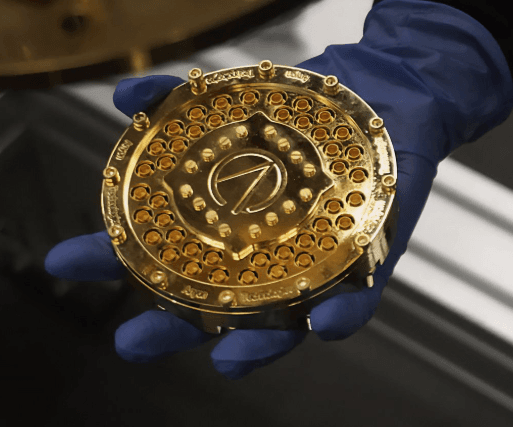 A modular quantum processor module held in a gloved hand — Anyon's QPU at its real, fingertip scale